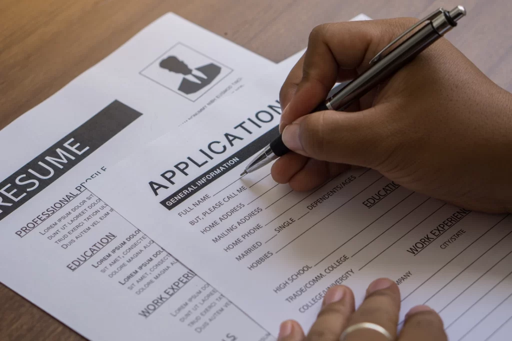 hands filling out job application